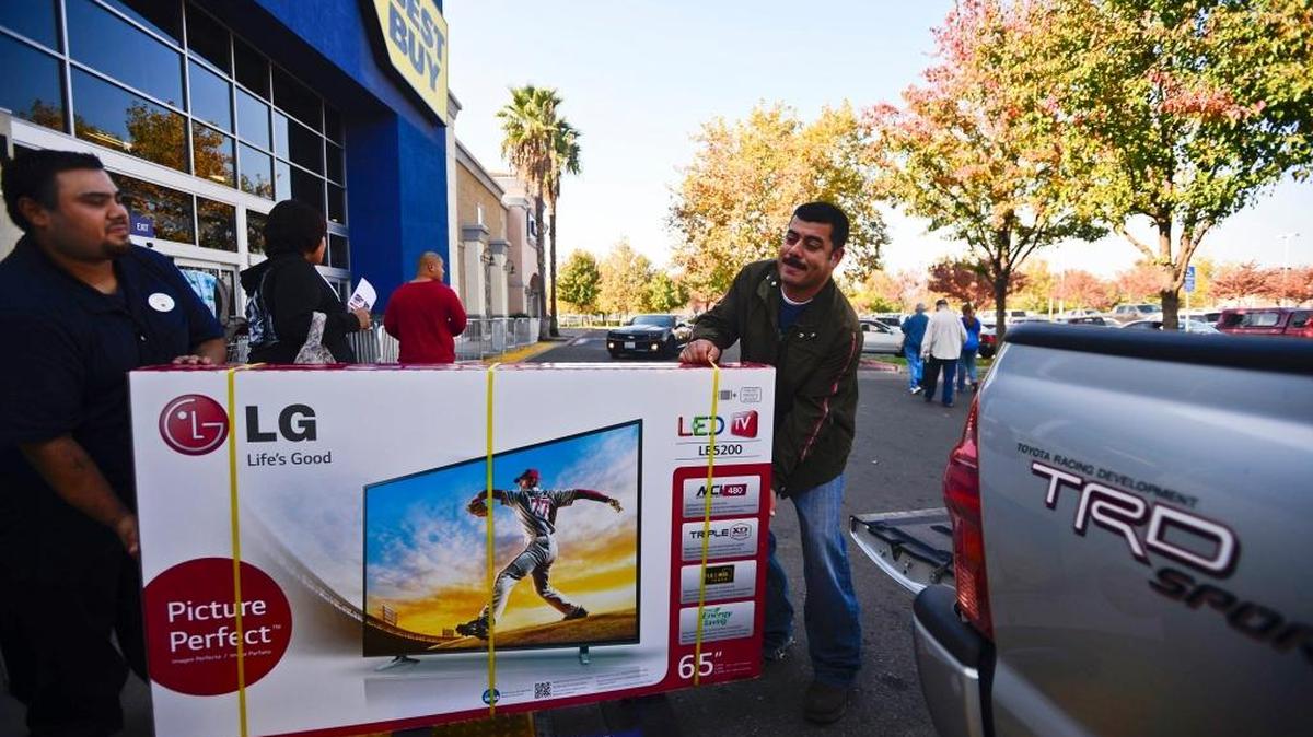 Atwater resident David Sanchez, 38, right, gets help loading a television into his truck from Arthur Guerro at the Best Buy on Olive Avenue in Merced on Black Friday last year.