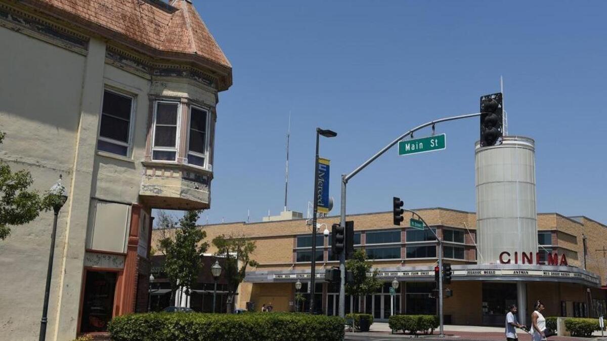 A family crosses the street on Main Street near K street in downtown Merced in August. The Merced City Council this week floated ideas to improve downtown, including assigning an officer on foot patrol to downtown, boosting code enforcement efforts, improving lighting, providing transportation to get students to visit and implementing a mobile outreach unit for the homeless.