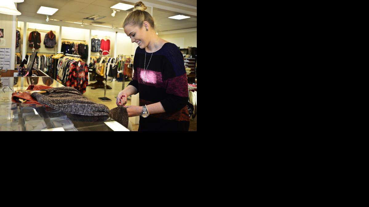 
Christina’s Fine Clothing sales associate Alison Kostecky, of Merced, prepares clothing for the upcoming Small Business Saturday at the store’s Merced location on Tuesday.

