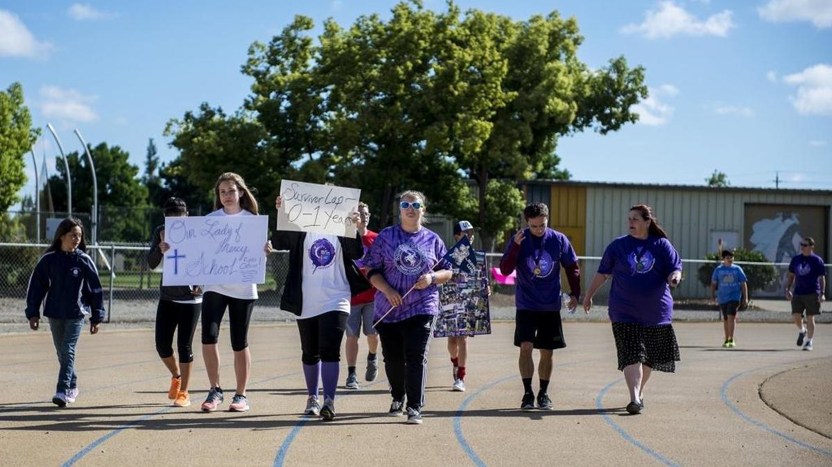 Cancer survivors and caregivers walk during the 24-hour Relay for Life event at Don Odishoo Field at Merced College in Merced, Calif., on Saturday, April 23, 2016. Donations raised from the event will be used to further cancer research as well as efforts to support survivors and patients in Merced.
