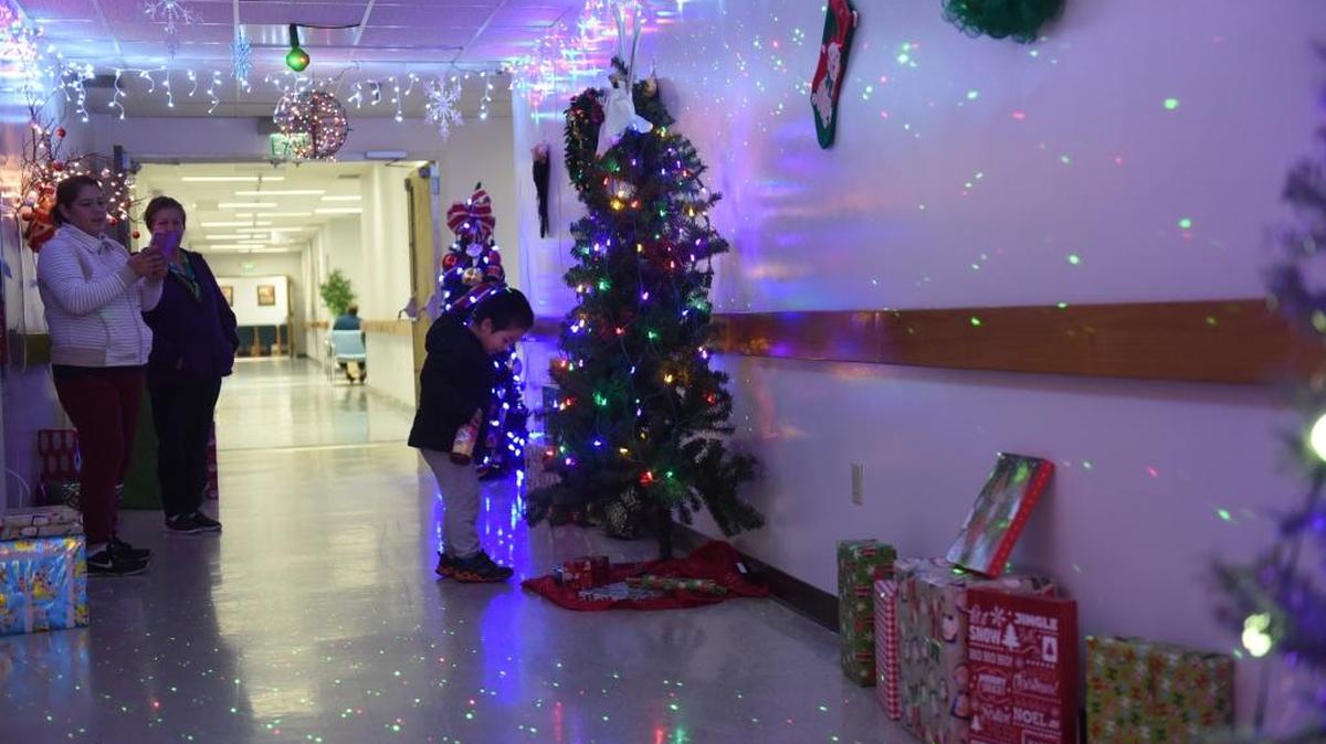 Cristoper Jimenez, 4, from Atwater has his picture taken by a Christmas tree in Castle Family Health Center on Dec. 9, 2016.