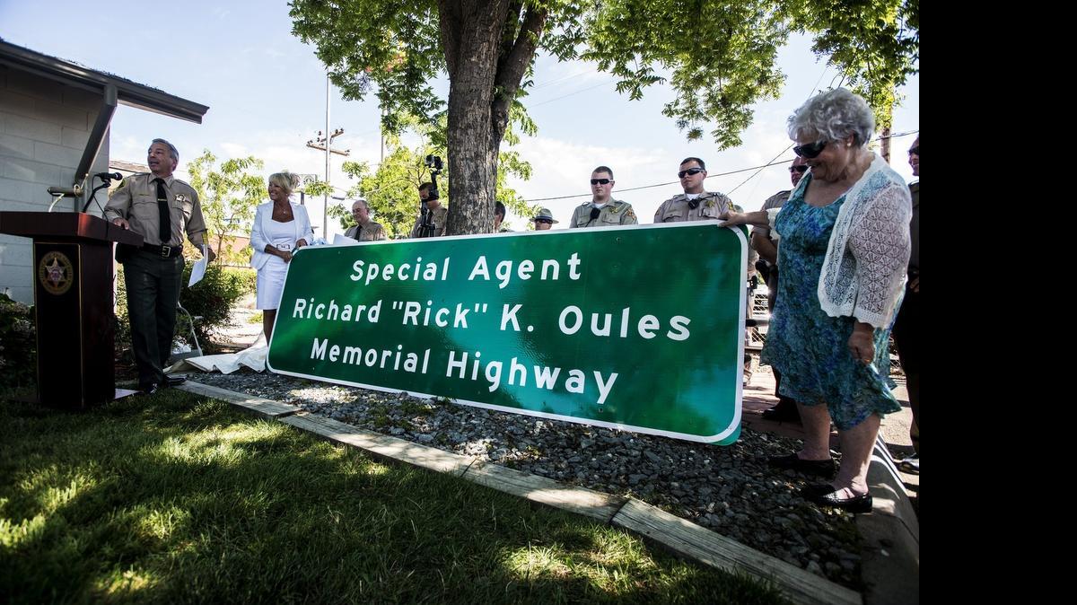 
The Special Agent Richard “Rick” Oules Memorial Highway sign is unveiled by Oules’ wife, Lisa, left, and mother, Pasty, right, during a ceremony at the California Department of Transportation facility on Motel Drive in Merced on Thursday. Oules, a former Merced County sheriff’s deputy, died of cancer in 2011. At left is Mark Pazin, chief of the Governor’s Office of Emergency Services Law Enforcement Division and former Merced County sheriff.
