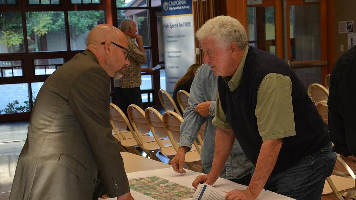 Farmer Robert McDonald inspects a map with Guy Preston, northern regional delivery manager for the California High-Speed Rail Authority, and discusses his concerns with the rail project at an open house in Los Banos Monday