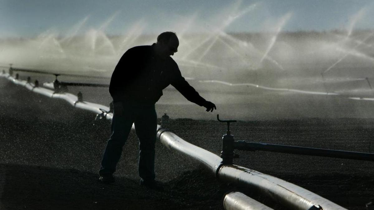 Daniel Errotabere, a farmer on the west side of the San Joaquin Valley, reaches for an irrigation valve on his farm, in 2007. The federal Bureau of Reclamation has promised west side farmers they’ll get at least 65 percent of their water allocation this year. Farmers had hoped this winter’s drought-busting rains would merit 100 percent allocation.