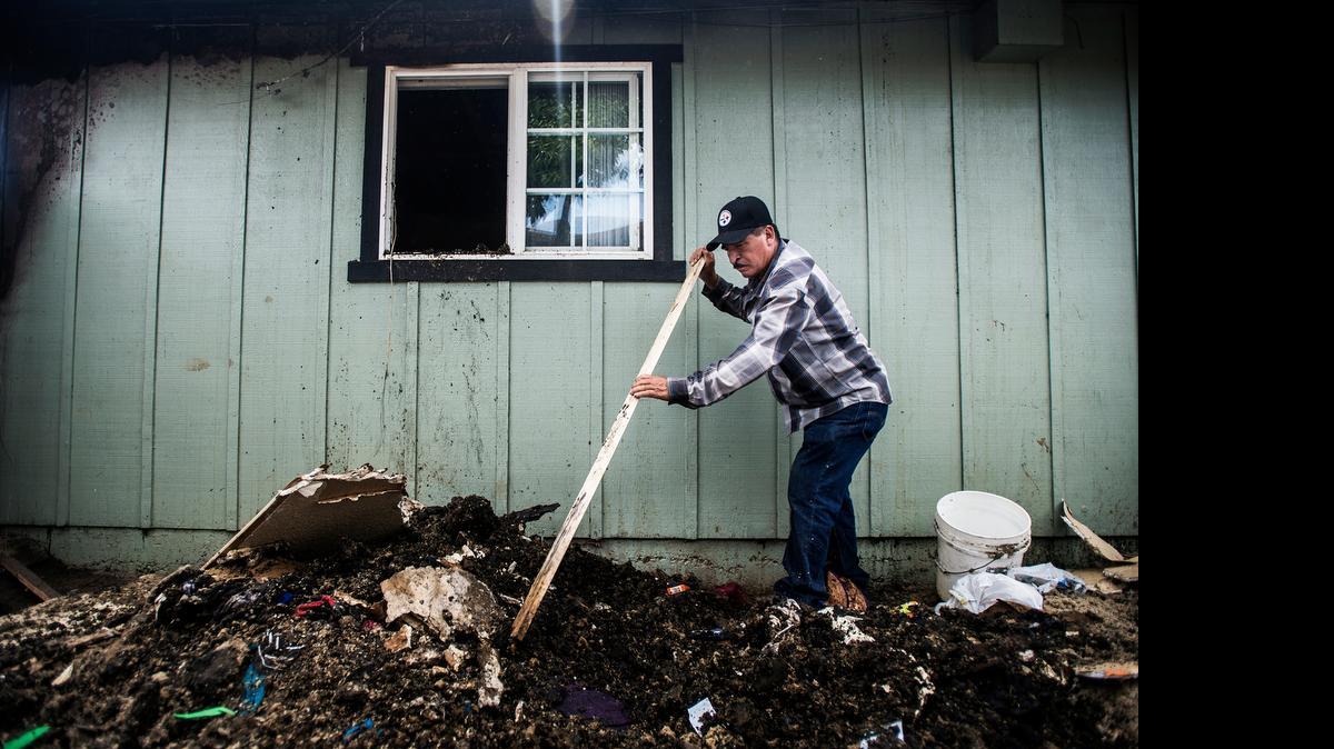 
Pascual Lopez of Merced helps friends with cleanup after an early morning apartment fire in the 1200 block of West Eighth Street in Merced, Calif., Wednesday, July 1, 2015. The structure fire, which is believed to have been sparked by a nearby burning car, displaced 14 people from their homes, six of whom are children, according to battalion fire Chief Billy Alcorn. The car fire is believed to be the result of arson.
