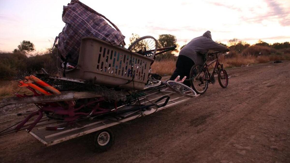In 39-degree temperature and before sunrise “Daniel” uses a bicycle to pull a cart loaded with metal to a recycler in nearby Mendota from his homeless camp about a mile away on Wednesday, Nov. 18, 2015.