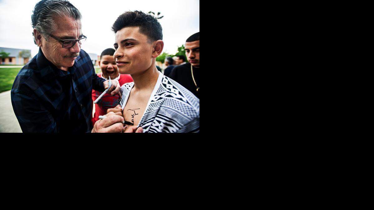 
Professional cutman and Planada native Jacob “Stitch” Duran signs the chest of Planada resident Jacinto Caballero, 14, during the Benefit for Boxing event at Cesar Chavez Middle School on Friday in Planada. Duran, along with the Merced County Sheriff’s Department, is working to revive youth boxing in the area.
