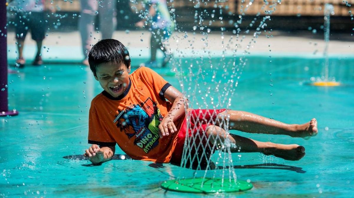 Enrique Zarate, 7, of Merced laughs as he plays in the Stephen Leonard Park splash pad in Merced on Saturday, June 25, 2016.