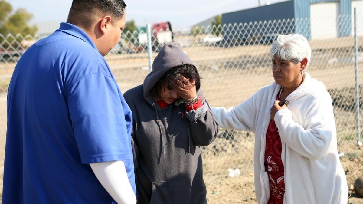 Maria Hernandez, a volunteer from Our Lady of Guadalupe Catholic Church in Mendota, tries to convince Maricela to seek medical attention at the homeless camp north of Mendota on Friday, Nov. 20. Maricela is showing serious signs of pneumonia. On the left is Juan Gamez from Clinica Sierra Vista of Fresno.