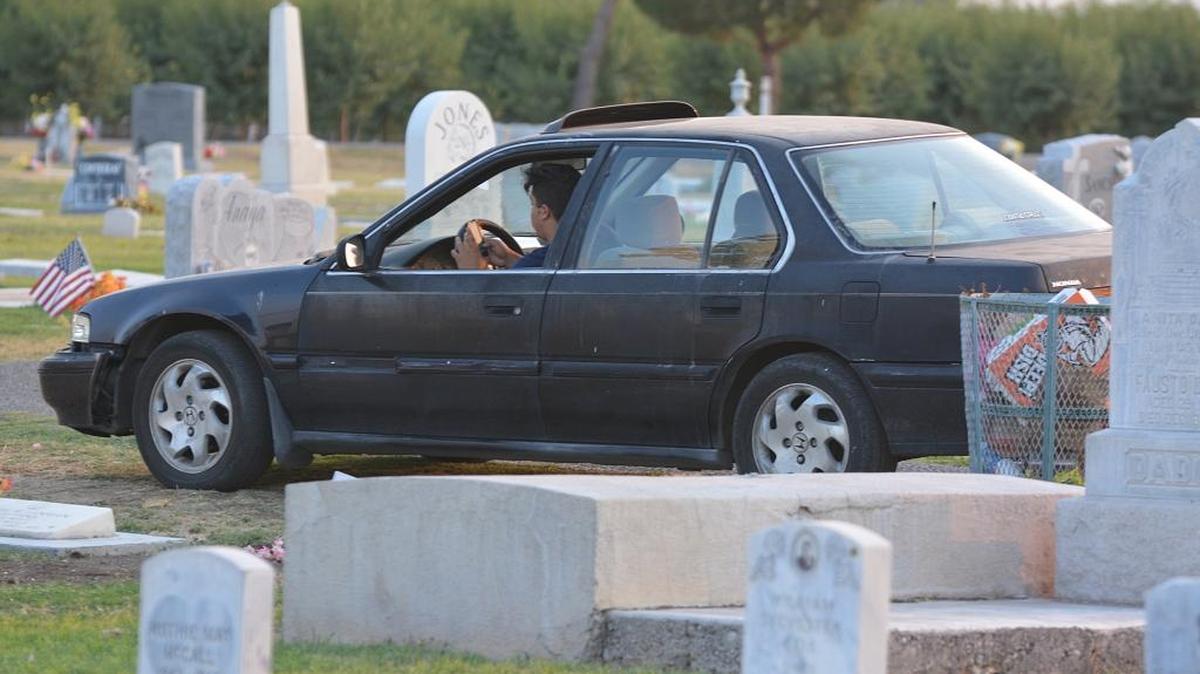 A “Pokémon Go” player stops his car in Los Banos Cemetery and swipes on his phone Monday, July 25, 2016.