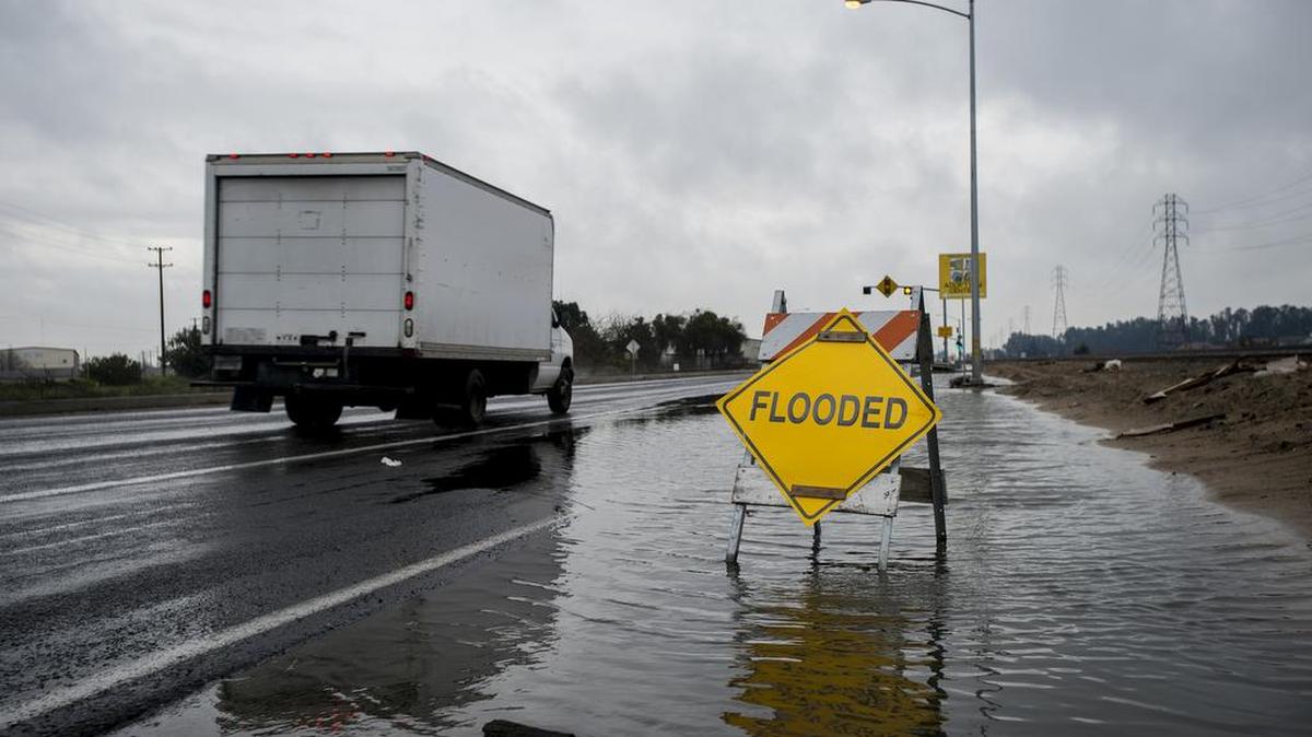 A truck drives past a flooded lane along Santa Fe Avenue during light rain showers in Atwater, Calif., on Saturday, Jan. 7, 2017.