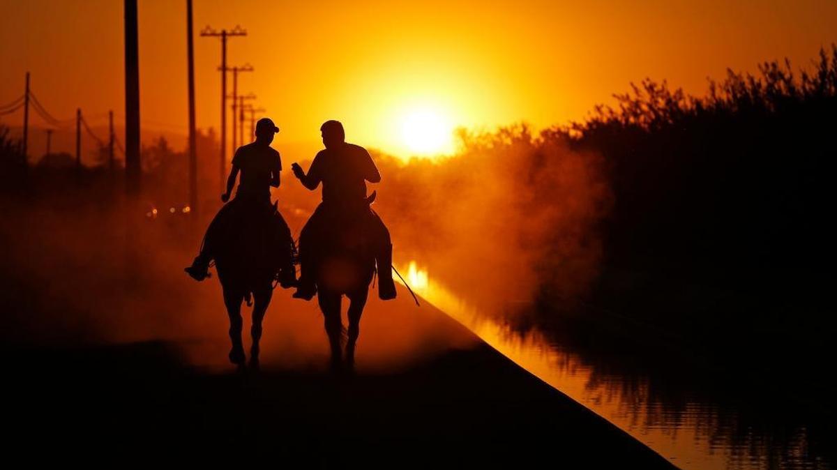 Two men ride on horseback along an irrigation canal in agricultural land near Modesto, Calif, on Sept. 17, 2015. Uranium, the stuff of nuclear fuel for power plants and atom bombs, increasingly is showing up in drinking-water systems in major farming regions of the U.S. West, as an unexpected by-product of irrigation and, increasingly, of drought and the overpumping of natural underground water reserves. (AP Photo/John Locher)