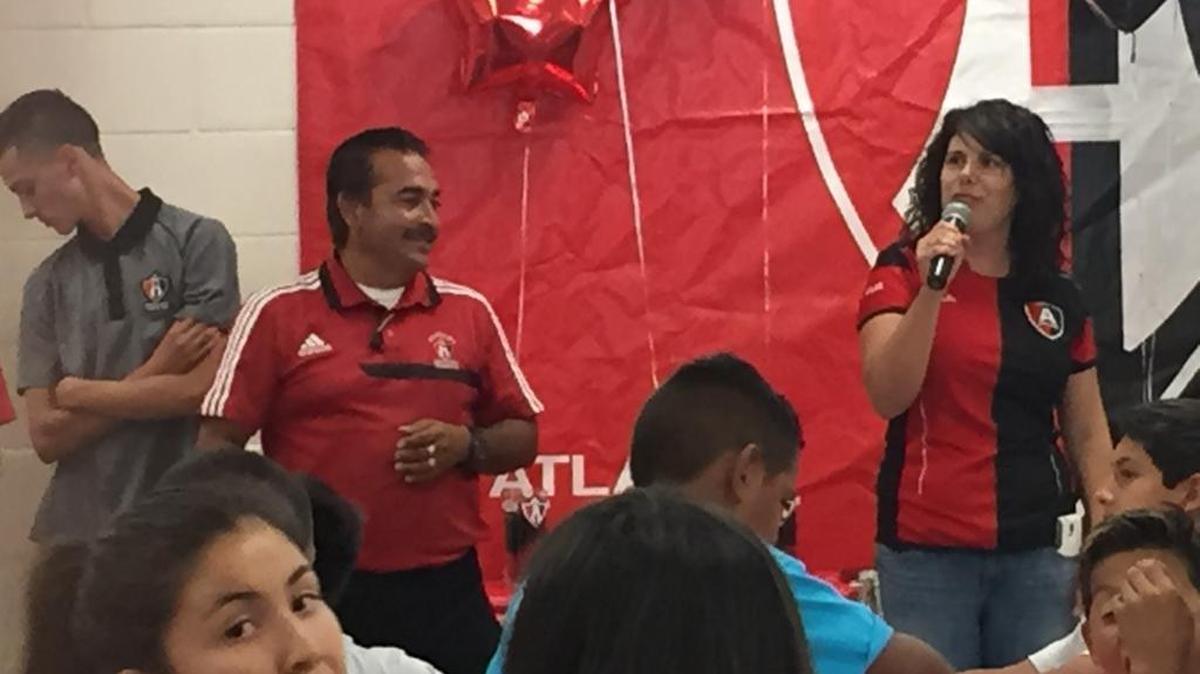 Fernando Aguilera, left, and Rosa Barragan, right, distribute awards during the one-year celebration of the Merced Soccer Parent/Youth Center at Stephen Leonard Park on Sunday in South Merced.