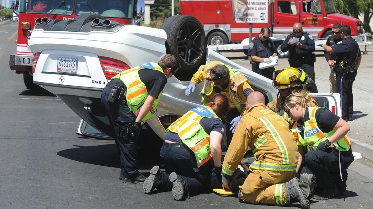 Los Banos emergency workers come to the aid of Aehayjit Sangha after a rollover accident along North Mercey Springs Road on Monday afternoon.