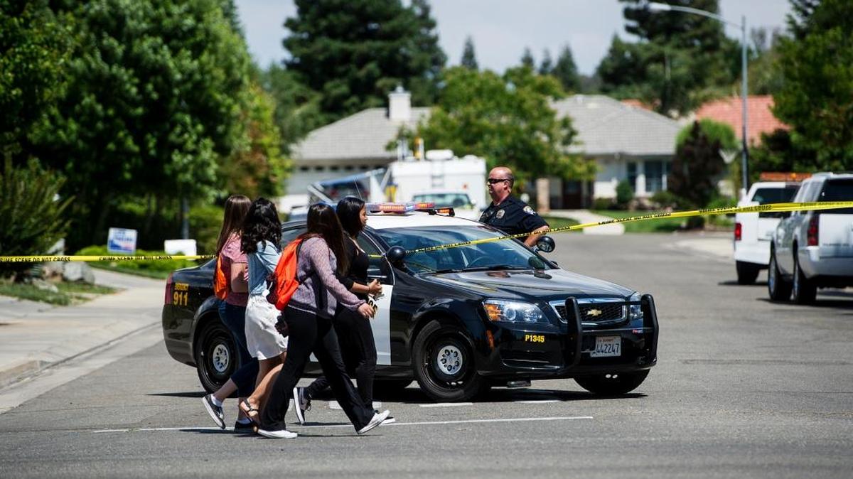 School children walk through the intersection of Kingfisher Court and Mansionette Drive as Merced Police investigate the scene of a shooting on Kingfisher Court in Merced, Calif., Wednesday, May 25, 2016. According to Merced Police Lt. Chris Goodwin, the shooting was not fatal.