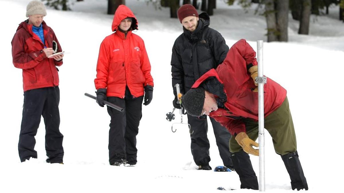 Frank Gehrke, right, chief of the California Cooperative Snow Surveys Program for the Department of Water Resources, checks the depth of the snowpack as he conducts the second manual snow survey of the season at Phillips Station on Thursday near Echo Summit.