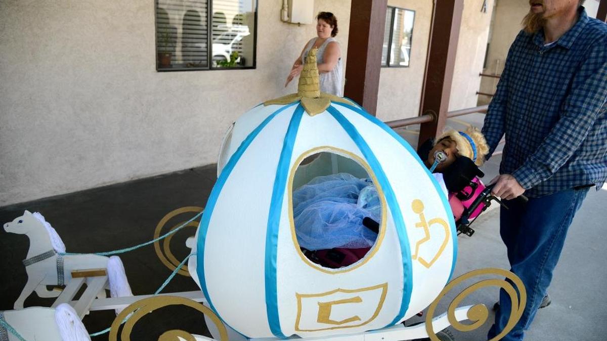 Nikki Chadwell’s uncle, Chris Mayo, pushes her in her wheelchair and the Cinderella carriage he built her for Halloween as she goes trick-or-treating to her special education classes on Friday, Oct. 30, 2015. Nikki, 8, is legally blind and has cerebral palsy.