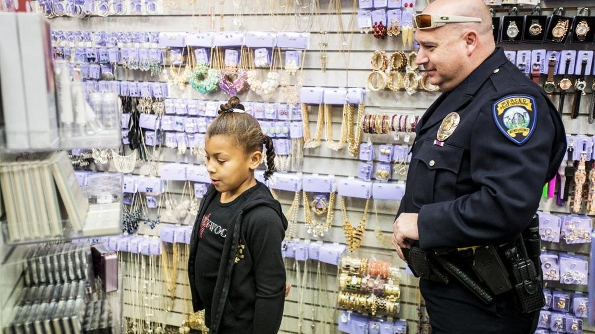 Merced resident Brooklynne White Whitnel, 8, shops for family members with Merced police Detective Jeff Horn at Claire’s during the seventh annual Shop With a Cop at the Merced Mall on Wednesday, Dec. 16, in Merced. Funds raised by the Merced Mall provided each child with money to spend on gifts for themselves and family members.