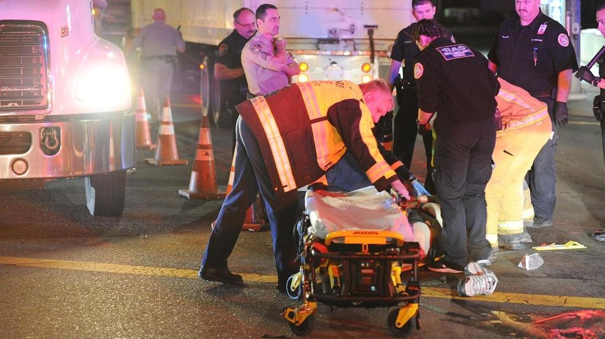 Emergency crews tend to a man who was hit by a big rig Wednesday night on Pacheco Boulevard at Sixth Street in Los Banos.