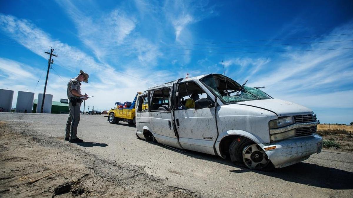 A California Highway Patrol officer investigates the scene of a single-vehicle crash that killed four farmworkers near Highway 152 and Island Road in Merced County, Calif., on Saturday, June 20, 2015.