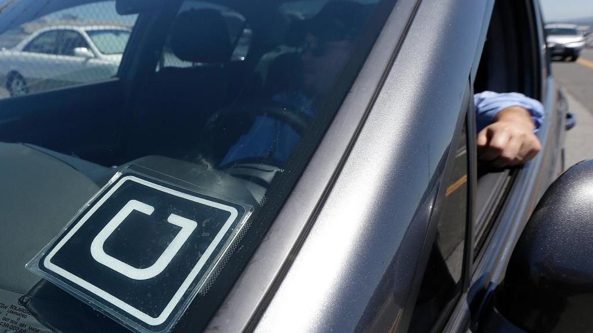 
Uber driver Karim Amrani sits in his car parked near the San Francisco International Airport parking area in San Francisco in July. Hilton is hailing the ride sharing service Uber to help guests reach its hotels and then explore the city where they are staying, the companies announced Tuesday, Sept. 1, 2015. 
