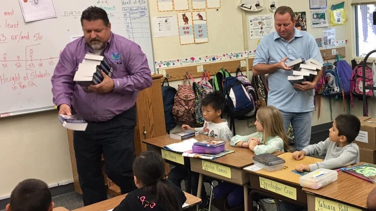 Merced Rotary Club members distribute books at Muir Elementary in Merced.