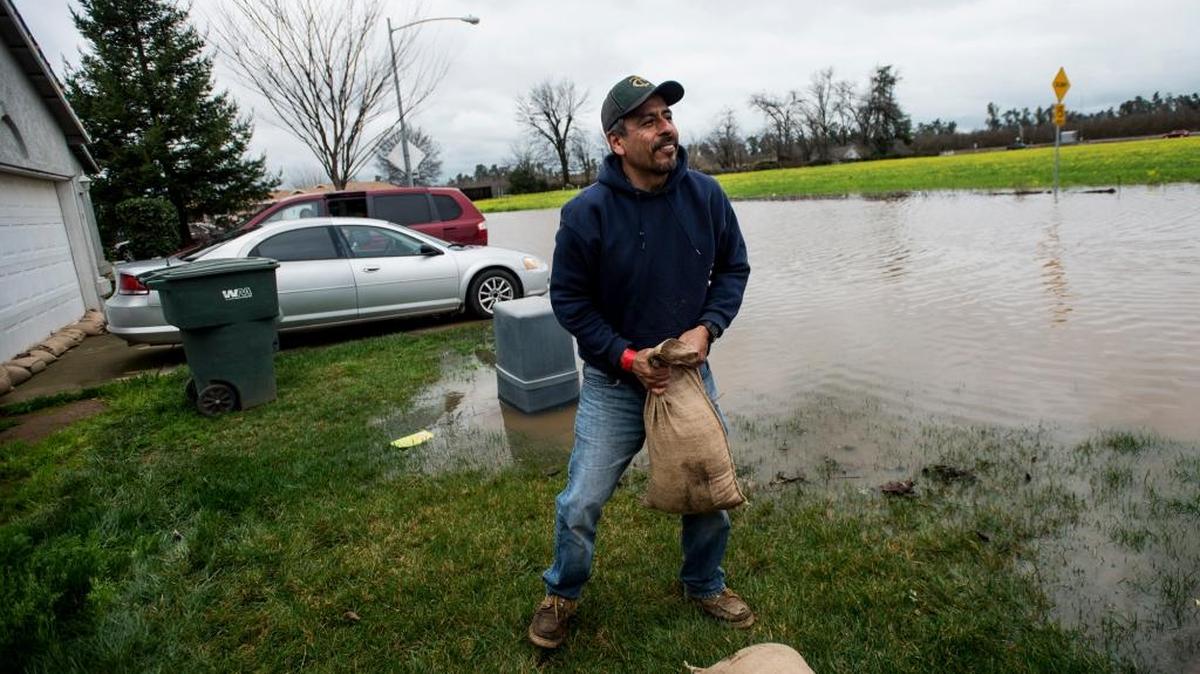Jesse Vargas, 44, places sandbags around his brother’s home in Le Grand on Saturday. According to authorities, flooding along Mariposa Creek forced some residents to evacuate their homes Saturday.