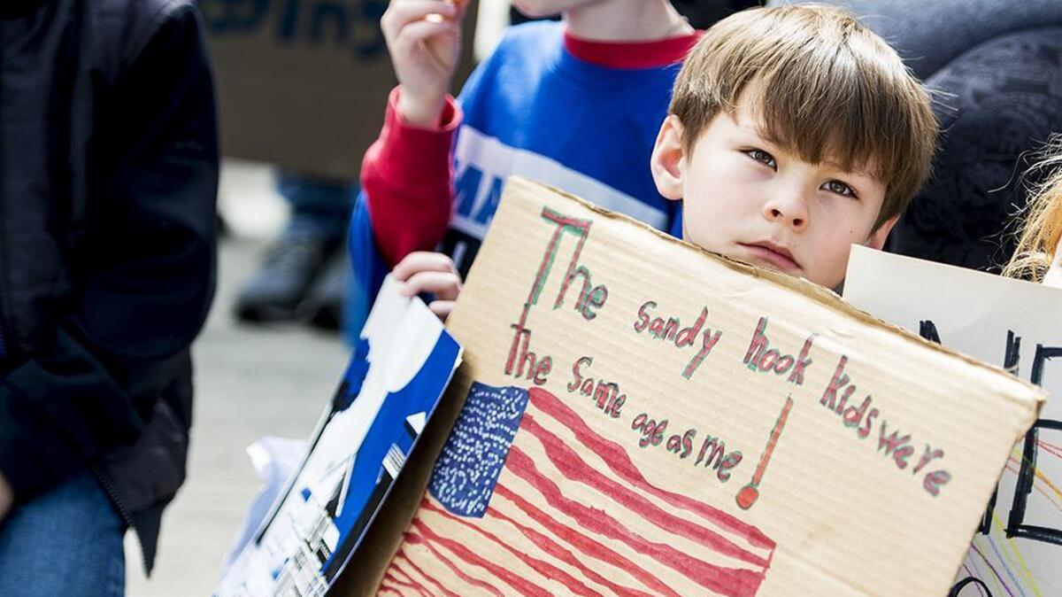 Ronan Davenport, 7, of El Portal, holds a sign which reads “The Sandy Hook kids were the same age as me!” during a “March for Our Lives” rally at Courthouse Park in Merced, Calif., on Saturday, March 24, 2018.