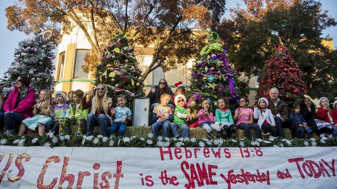 People wave from the Saint Paul Lutheran School float Saturday during the 22nd annual Merced Hometown Christmas Parade downtown, presented by the Active 20-30 Club of Merced.