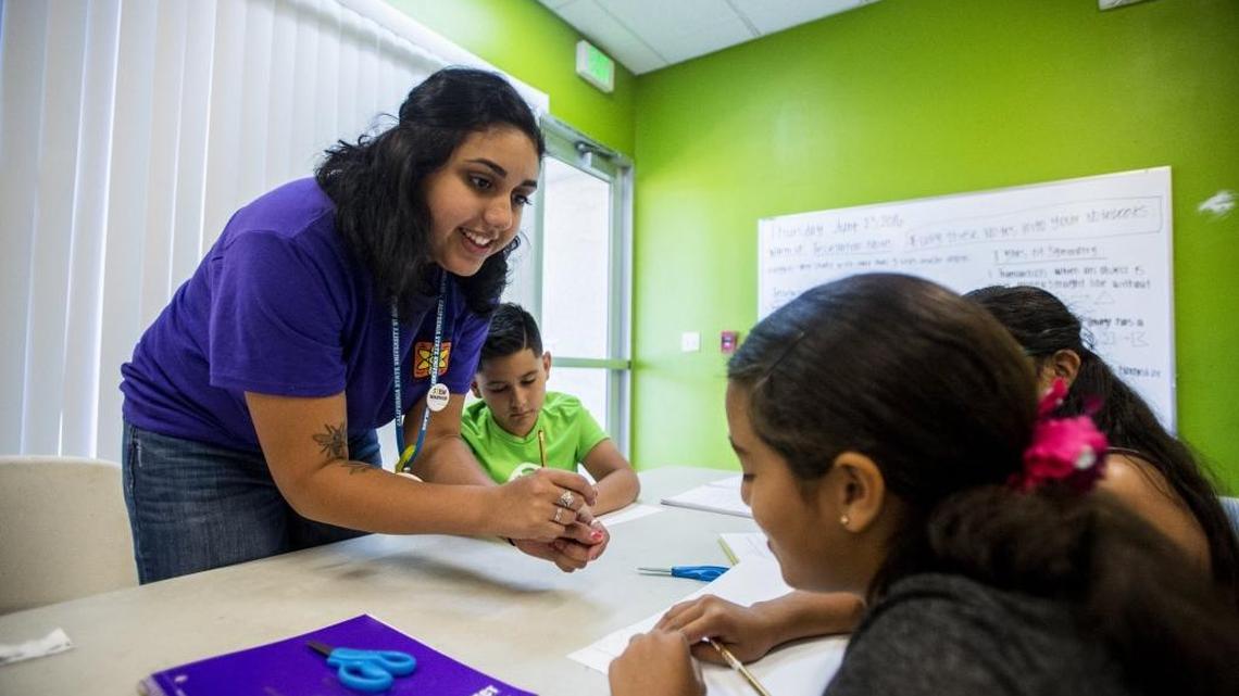 California State University, Stanislaus, student Adriana Covarrubias, 20, works with children to create patterns using shapes during Fun Brain Gain STEM Camp at the Boys & Girls Club in Merced, Calif., on Thursday, June 23, 2016. The program, which consists of Stanislaus State students teaching children about science, technology, engineering and math, or STEM, is one of many offered during the summer to keep children active.