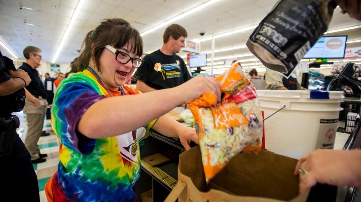Maggie Mayo, 19, of Merced, bags groceries for a customer during the Bagging For Bucks fundraiser at SaveMart in Merced on Tuesday. Athletes and law enforcement officers assisted shoppers with the bagging of groceries and escorted shoppers to their vehicles. All tips received will be donated to the Special Olympics to support the Law Enforcement Torch Run. Officers from UC Merced, the California Highway Patrol and Merced firefighters teamed up with athletes and Save Mart to raise money for the cause.