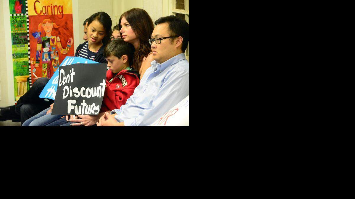 
Parents and children hold signs protesting boundary changes for elementary schools during a Merced City School District meeting Tuesday.
