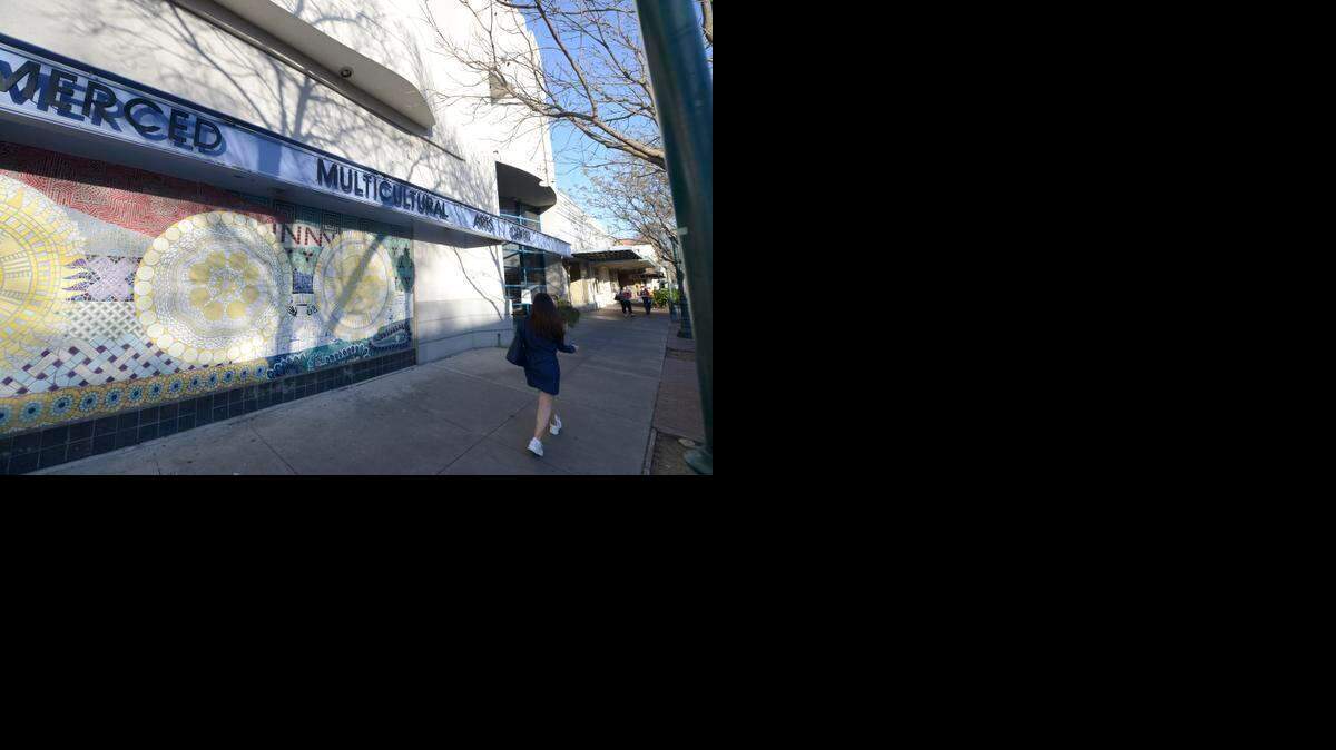 
Pedestrians walk by the Merced Multicultural Arts Center on Thursday. The center will be laying off three employees.
