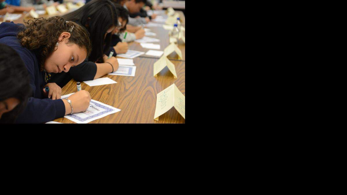
Cesar E. Chavez Middle School eighth grader Alejandra Tenorio, 13, signs her “high school diploma” during a Project 10% session at the Planada school last spring.
