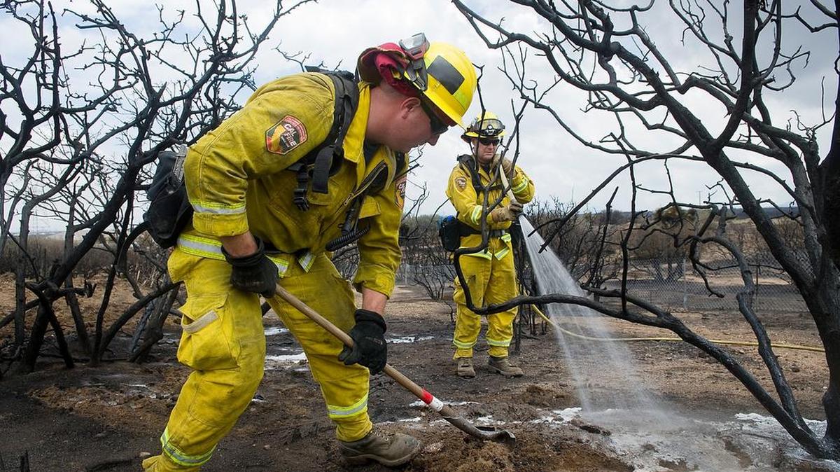 
Ryan Howell, left, and Adam Clark of Cal Fire continue hosing down hot spots on the North fire on July 20 in rural Phelan. Despite heavy rains the day before, some fire work continued on the more-than-4,000-acre fire.
