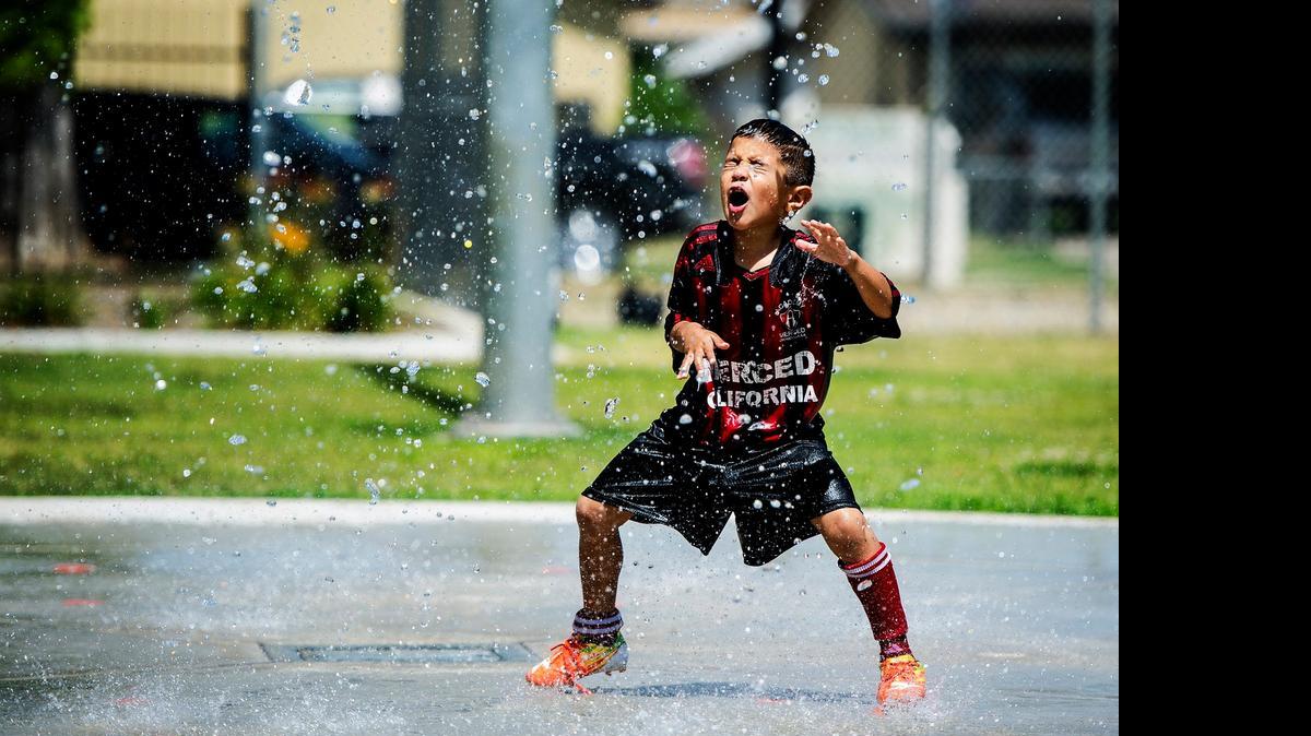 
Ismael Zamudio, 5, of Atwater, plays on the splash pad at McNamara Park in Merced on a hot Tuesday. The high temperatures in Merced are forecast to be in the triple digits until late this week.
