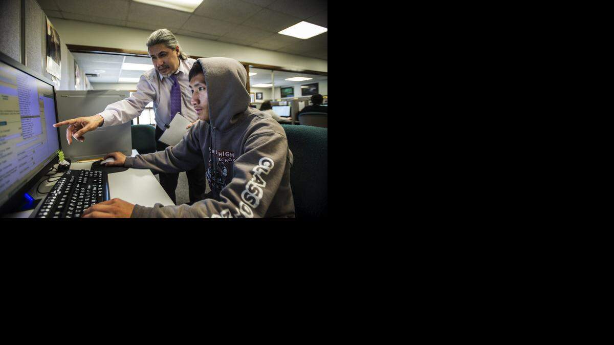 
Cheng Chang, 22, of Merced, front, is assisted by Jaime Gutierrez, an employment training specialist at the Merced County Department of Workforce Investment in Merced on Wednesday. The department, which received a $950,000 grant this month from the California Employment Development Department, assists laid-off employees in their search for new opportunities.

