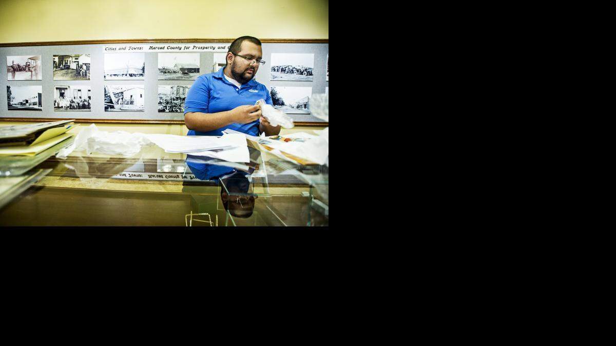
UC Merced student and museum volunteer Ramon Baragan, 20, sorts through commemorative pins and coins Wednesday as preparation continues for the “Promoting Merced: A County of Many Resources” exhibit at the Merced County Courthouse Museum. This year will mark the centennial of the Panama-Pacific International Exposition in San Francisco. Artifacts such as a 1915 Merced County booklet, an original jewel from Tower of Jewels and Pan-Pacific International Exposition medallions will be on display starting Thursday.
