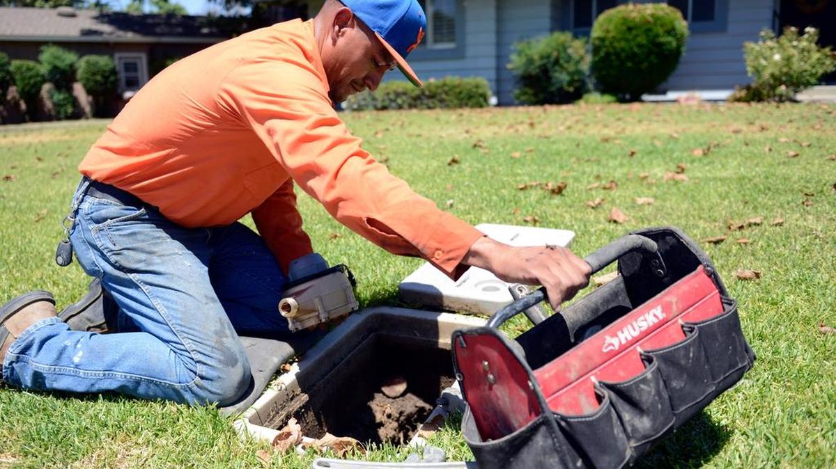 
Merced Water Department worker Jesus Montes, 35, of Merced installs a water meter in the front of a house on Tenaya Drive in Merced on Wednesday. Public employees could be affected by a push to only allow a local vote to approve any new pension benefits or upgrades to current ones.

