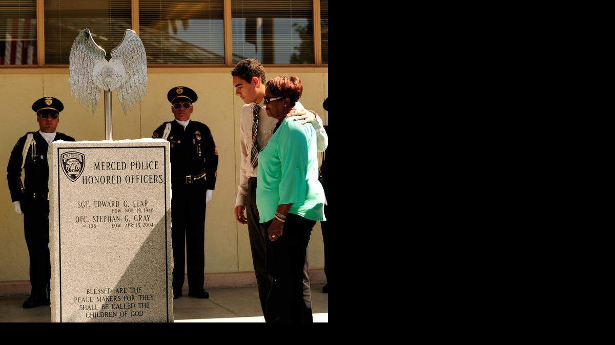 
Slain Merced police Officer Stephan Gray’s son, Isaiah Gray, 16, stands with his grandmother and Officer Gray’s mother, Lonather Gray, during memorial dedication ceremonies last April.

