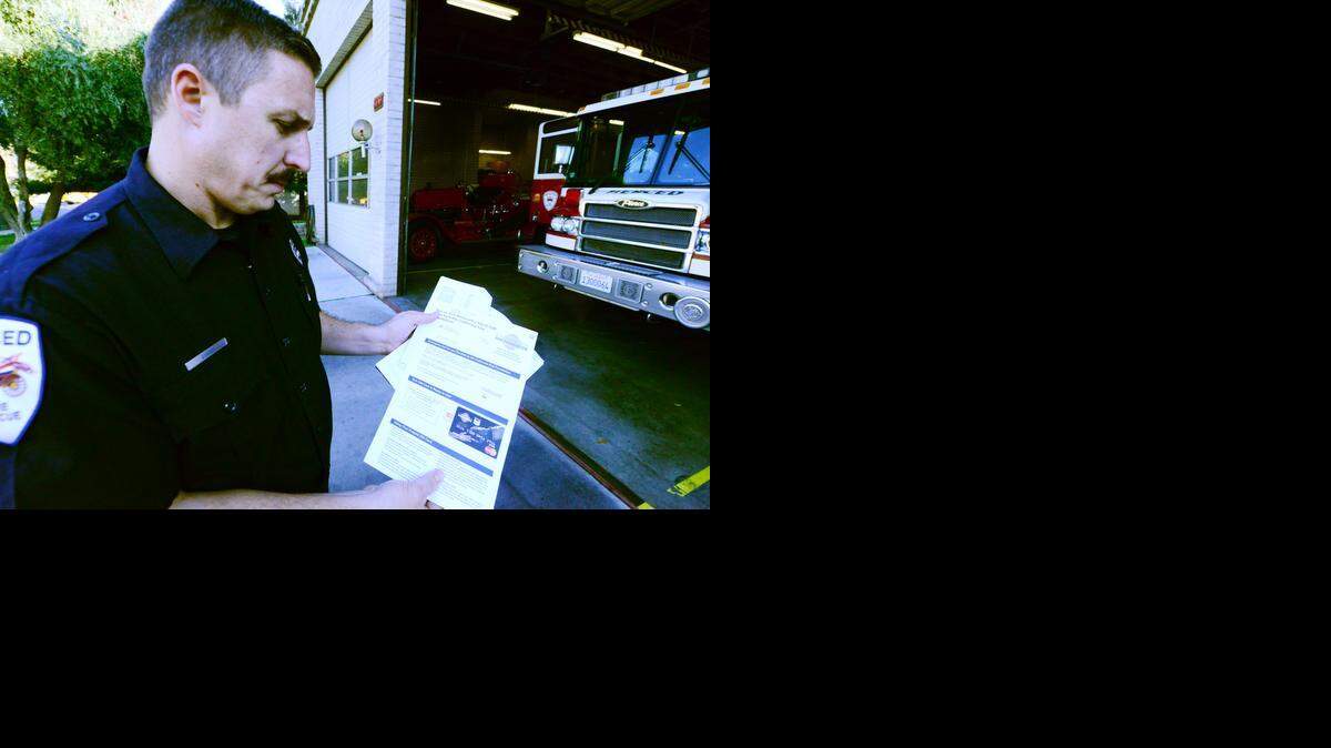
Engineer Jim Evans holds a $100 gift card on Monday that Merced Fire Department battalion chiefs can give out to victims of fire or natural disaster. The cards are paid for through donations to the California Fire Foundation.
