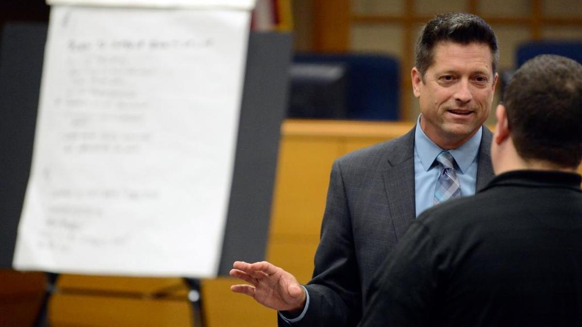 Gary Phillips, a consultant with Bob Avery & Associates, speaks to a Merced resident at City Hall in Merced on Monday near a list of the traits residents said they want to see in the next city manager. City Council is set to conduct interviews Saturday.