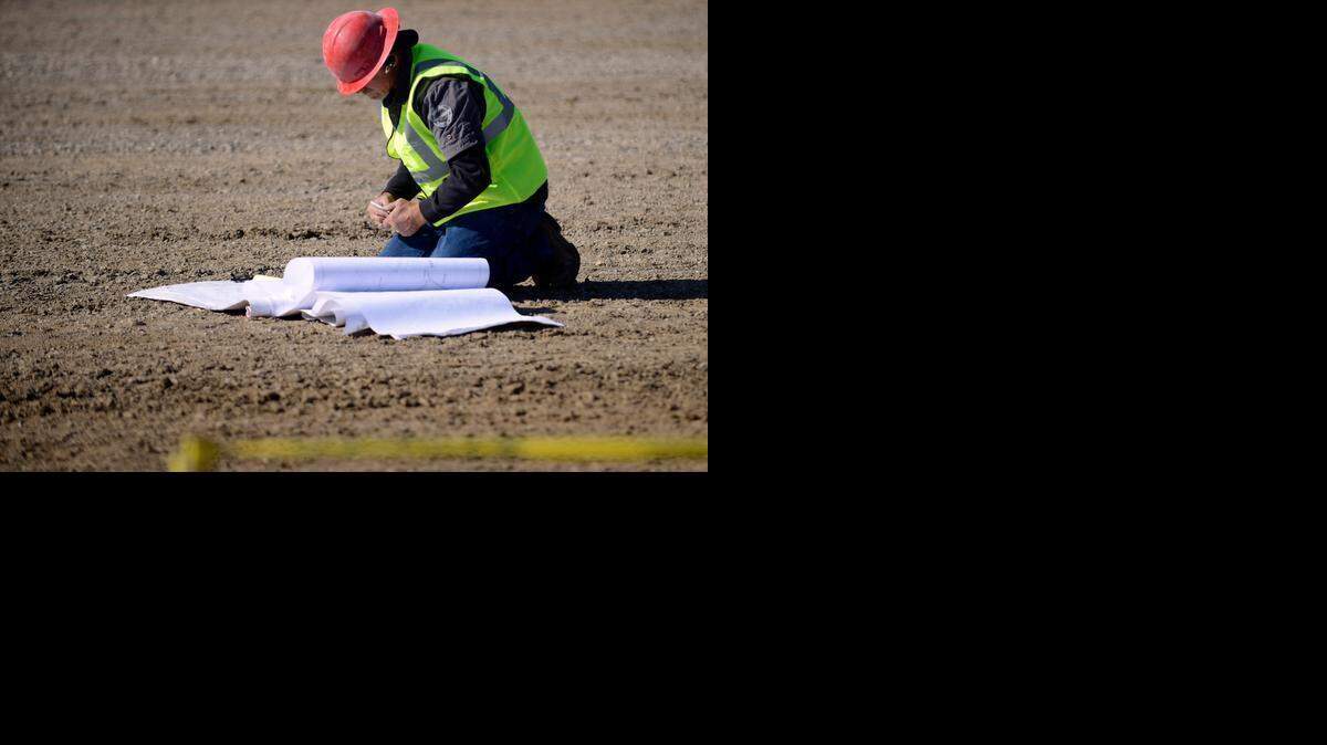 
A worker from G&G Construction Co. of Atwater looks at plans Friday for the Hilmar Cheese Co. barn project, the first new construction in 33 years at the Merced County fairgrounds. Officials held a groundbreaking ceremony for the 33,800-square-foot building Friday.
