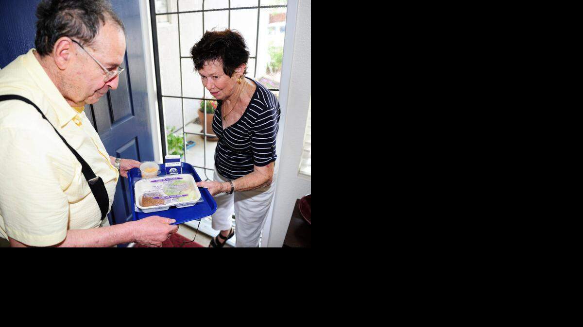 
Shirly Pietrzyk delivers a fresh meal to the home of Bernard Robins, 71, in Atwater last August.
