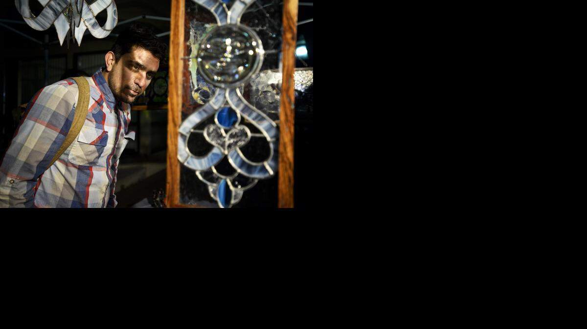 
Garland Daniel, 33, of Merced looks at stained-glass artwork by Merced artist Marty Bobrowski, 49, on Saturday during the year’s first Merced Art Hop.

