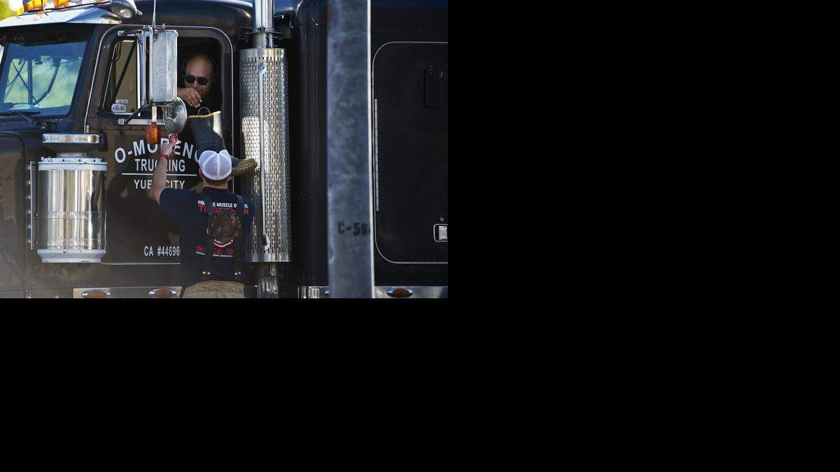 
A truck driver donates money to a Merced City firefighter during the Fill The Boot fundraiser at the intersection of West Olive Avenue and G Street in Merce on Monday. The money raised will benefit the Muscular Dystrophy Association.
