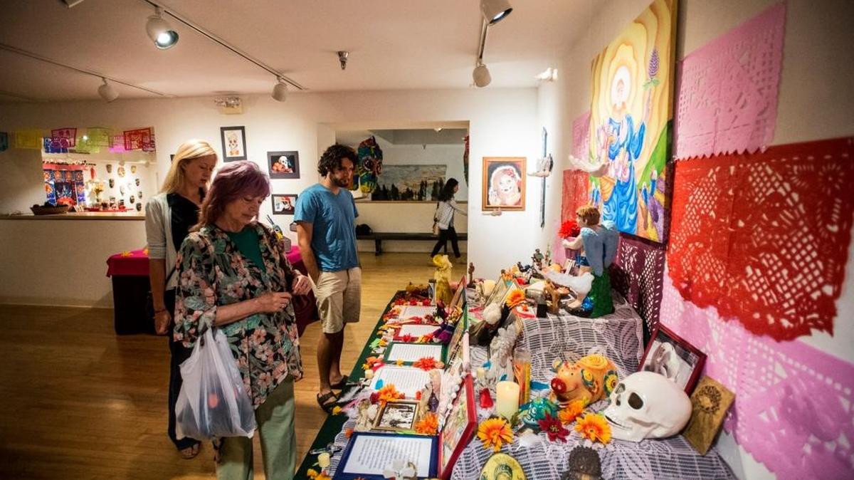Patrons look at an altar that was part of October Art Hop’s “Day of the Dead” exhibit at the Merced Multicultural Arts Center.