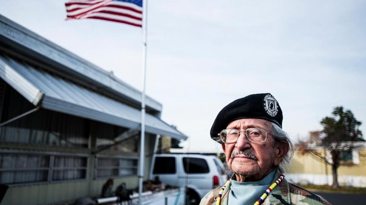 United States Army and Marine Corps veteran Frank Paredes, 95, of Atwater poses for a portrait near his American flag, which he lowered to half-staff outside his home in Atwater on Monday, Dec. 7, 2015.