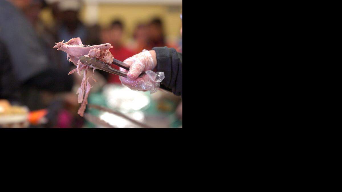 
A volunteer serves the needy during the Merced Rescue Mission Thanksgiving Feed at the American Legion Hall in Merced in 2012. 
