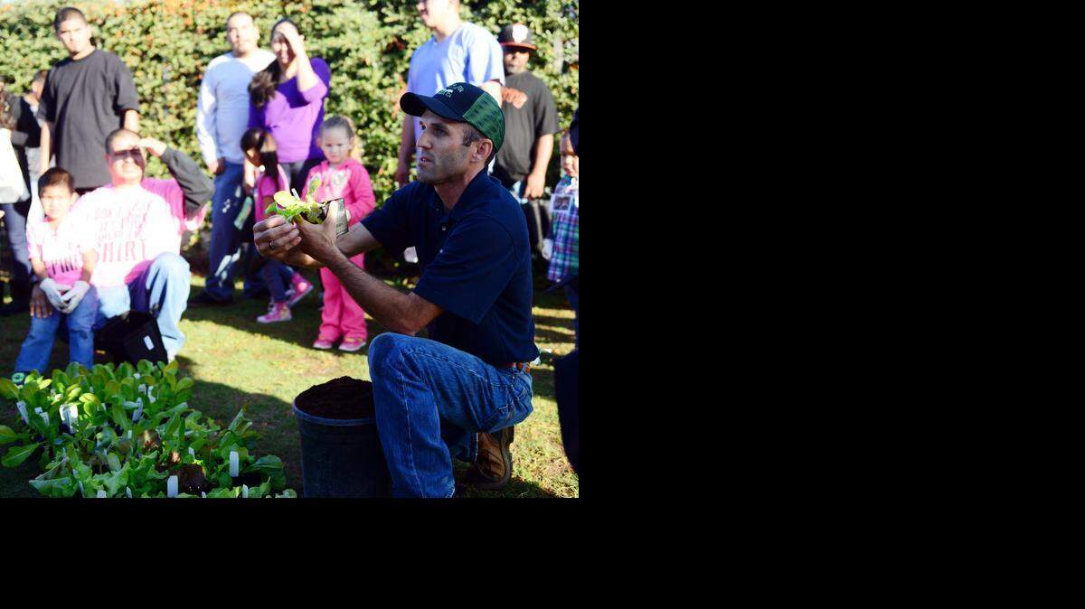 
Merced College horticulture instructor Bryan Tassey talks to children and their parents about vegetable gardens during the “Guys Diggin’ Dirt” event at Fairside Head Start in Merced on Friday. The event focused on nutrition, agriculture and the importance of male role models.
